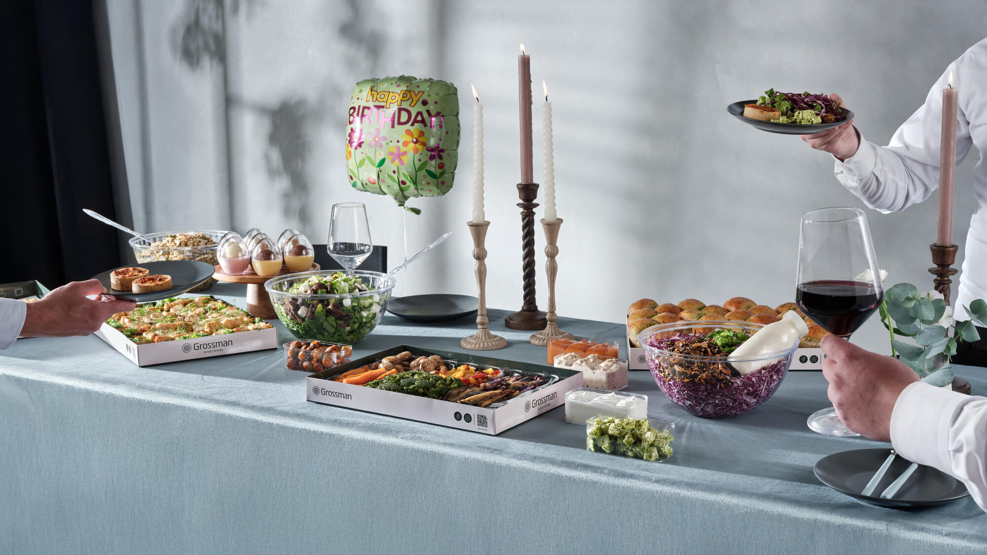 תמונות אווירה של ארוחה בייסיק, שולחן יום הולדת, עם 3 קערות סלט מגשי אנטי פסטי לחמניות שום, מתבלים וקינוחי כוסות